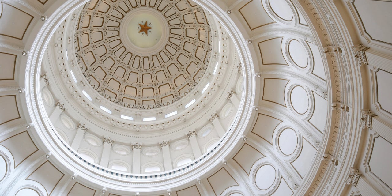 Interior view looking up at an ornate domed ceiling with layered arches and a central star.