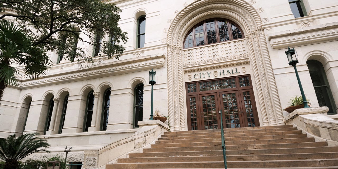 Exterior view of a historic stone city hall building. 