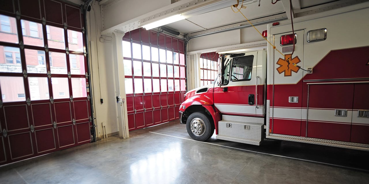 Interior view of a firehouse with an ambulance parked in one of the bays.