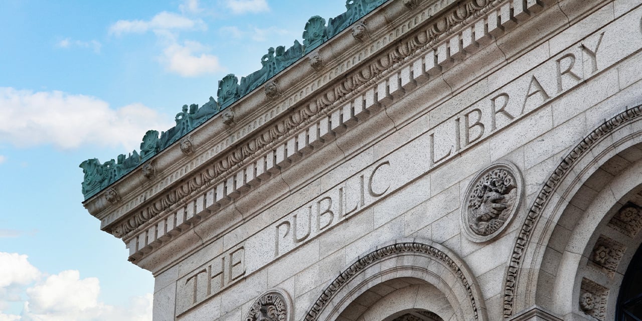 Exterior view of the top of a historic stone public library building.